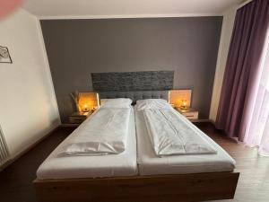 um quarto com duas camas e duas luzes em duas mesas em Pension Hoogerland em Velden am Wörthersee