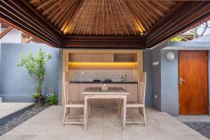 an outdoor kitchen with a table and two chairs at Kings Villas Sanur by Moria in Denpasar