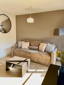 sala de estar con sofá y mesa en Bel appartement cosy dans résidence avec piscine 5 minutes plage, en Messanges