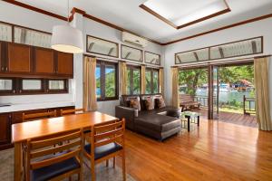 Koh Chang Longstay Resort في كو تشانغ: غرفة معيشة مع طاولة وأريكة