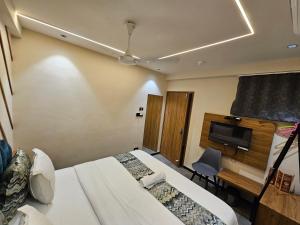 Habitación de hotel con 2 camas y TV de pantalla plana. en Hotel Nova Palm, en Rajkot
