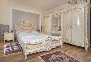 a white bedroom with a large bed and a mirror at ZiRa Residence Brasov in Braşov