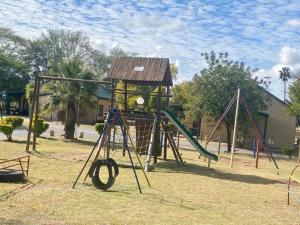 a playground with a slide and a swing at 20 Pendleberry Holiday Resort in Bela-Bela