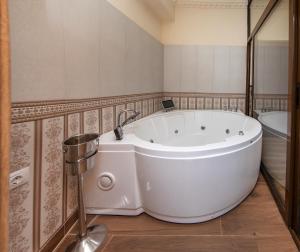 a large white tub in a bathroom with a bath tub at ZiRa Residence Brasov in Braşov