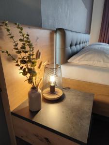 uma mesa com uma vela e um vaso em cima de uma cama em Pension Hoogerland em Velden am Wörthersee
