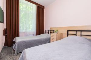 1 dormitorio con 2 camas y ventana en Seven en Vyshneve