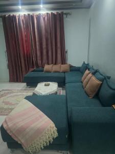 uma sala de estar com um sofá azul com almofadas em sunwing pyramids view em Al Mahallah Al Kubra