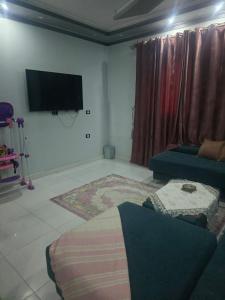 uma sala de estar com um sofá e uma televisão de ecrã plano em sunwing pyramids view em Al Mahallah Al Kubra