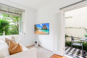 een woonkamer met een witte bank en een raam bij Cosy Inner West Studio with Courtyard in Sydney