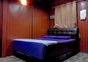 a small bed in a room with purple sheets at AISHAH GUEST HOUSE in Perhentian Island