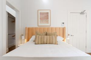een slaapkamer met een wit bed en een houten hoofdeinde bij Cosy Inner West Studio with Courtyard in Sydney