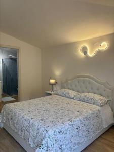 um quarto com uma cama com um edredão branco em La Grotta em Urzulei