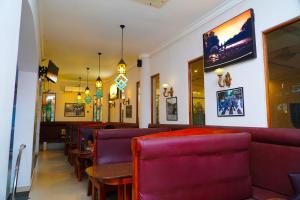 una sala da pranzo con sedie e tavoli viola di Tilko City Hotel Jaffna a Jaffna