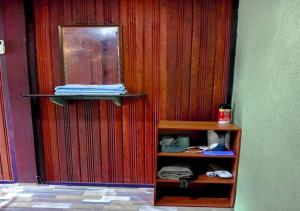 a room with a wooden wall with a shelf at AISHAH GUEST HOUSE in Perhentian Island