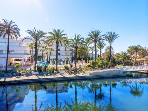 een resort met palmbomen en een zwembad bij VIVA Eden Lago in Port d'Alcudia