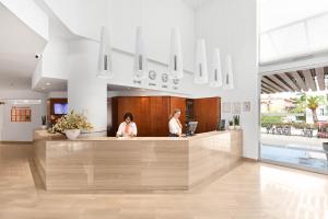 two women standing at a counter in a lobby at VIVA Eden Lago in Port d'Alcudia