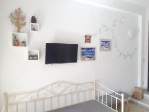 einen Flachbild-TV, der an einer weißen Wand hängt in der Unterkunft Bellagio in Castelsardo