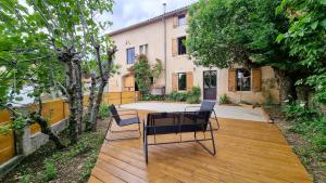 a patio with a table and chairs in front of a building at Le Relais de Diligence Balnéo & Sauna in Salsigne