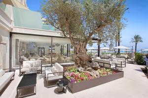 a patio with a tree and flowers in front of a building at VIVA Golf Adults Only 18+ in Port d'Alcudia