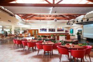 プラヤ・デ・ムロにあるVIVA Blue & Spaの赤い椅子とテーブルが備わるレストラン