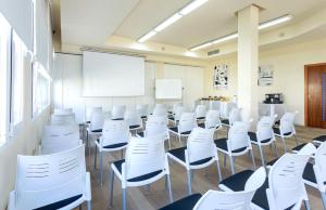 an empty classroom with white chairs and a whiteboard at VIVA Blue & Spa in Playa de Muro +45 photos