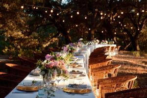 a long table with plates and flowers on it at Predi Son Jaumell Hotel Rural in Capdepera