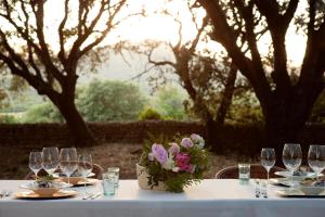 - une table avec des verres à vin et un vase de fleurs dans l'établissement Predi Son Jaumell Hotel Rural, à Capdepera
