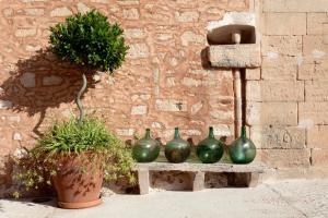 a group of green vases sitting on a stone bench at Predi Son Jaumell Hotel Rural in Capdepera