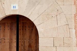 a building with a wooden door with a sign on it at Predi Son Jaumell Hotel Rural in Capdepera