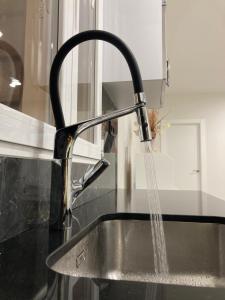 a kitchen sink with water coming out of a faucet at Mon Art in Logroño +24 photos
