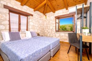 een slaapkamer met een bed, een bureau en ramen bij Villa Artemisia by Villa Plus in Ágios Nikólaos