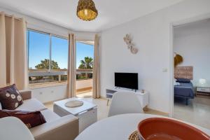 a living room with a couch and a tv at Vistamarina 403A By IVI Real Estate in Torremolinos
