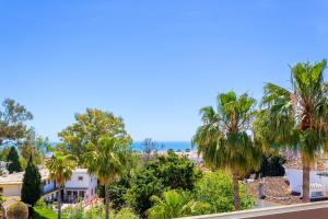 een uitzicht vanaf het balkon van een huis met palmbomen bij Vistamarina 403A By IVI Real Estate in Torremolinos