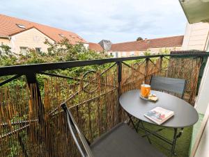 a small table on a balcony with a drink on it at Le Repaire - 10min Disney - Familial - Centre Ville in Bailly-Romainvilliers