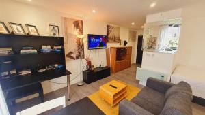 シェフィールドにあるCompact Studio Serviced Apartment Sheffield City Centre - Netflix, WiFi, Digital TVのソファとテレビのあるリビングルーム