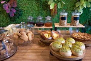 a table topped with plates of pastries and jars of food at Hotel Aloisi in Lecce