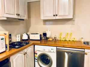 a kitchen with white cabinets and a dishwasher at The Bakers Cottage in Armidale