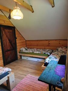 een kamer met 2 bedden en een tafel in een hut bij Domek w Łupkowie in Komańcza