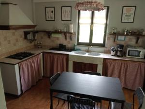 a kitchen with a table and a sink and a counter top at Casa Chiarli-Belforte Monferrato in Tagliolo Monferrato
