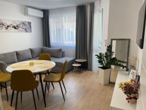 ein Wohnzimmer mit einem Sofa, einem Tisch und Stühlen in der Unterkunft Nova City Apartments in Warna