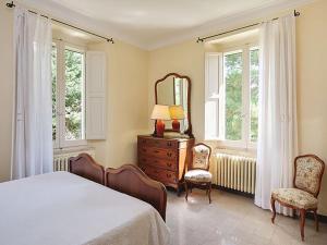 a bedroom with a bed and a mirror and two chairs at Villa delle Marche by BarbarHouse in Rosciano +55 photos