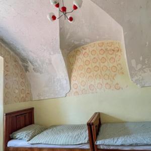a room with two beds and a ceiling at Ubytovanie v Kláštore - Hostel in Rožňava