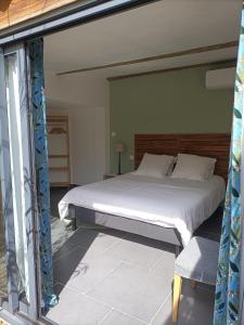 um quarto com uma cama grande e uma janela em Maisonnette tout confort em Rochefort-du-Gard