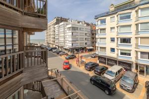 een uitzicht op een straat met geparkeerde auto's en gebouwen bij Guesthouse Westende in Middelkerke