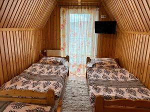 2 camas en una habitación con ventana en Pokoje Gościnne U Gordona en Poronin