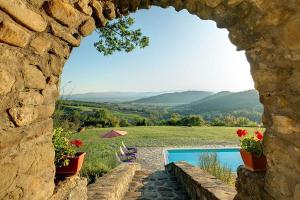 Una vista a través de un arco de piedra de una piscina. en Villa Torre Luna by Mmega, en Misciano 13 fotos más