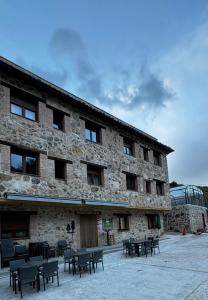 ArmallonesCasa rural Gerardo的一座前面有桌椅的建筑物