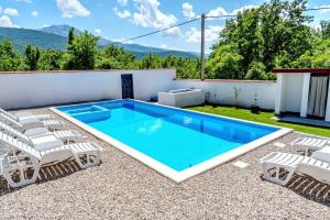 a swimming pool on a patio with chairs and a swimming poolvisor at Villa Green in Mostar