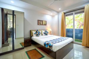 a bedroom with a bed and a large window at Luxurious Nirvana Apartment 2BHK in Vagator