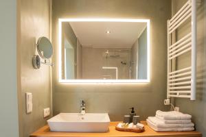 a bathroom with a sink and a large mirror at Hotel Seeblick in Thülsfeld